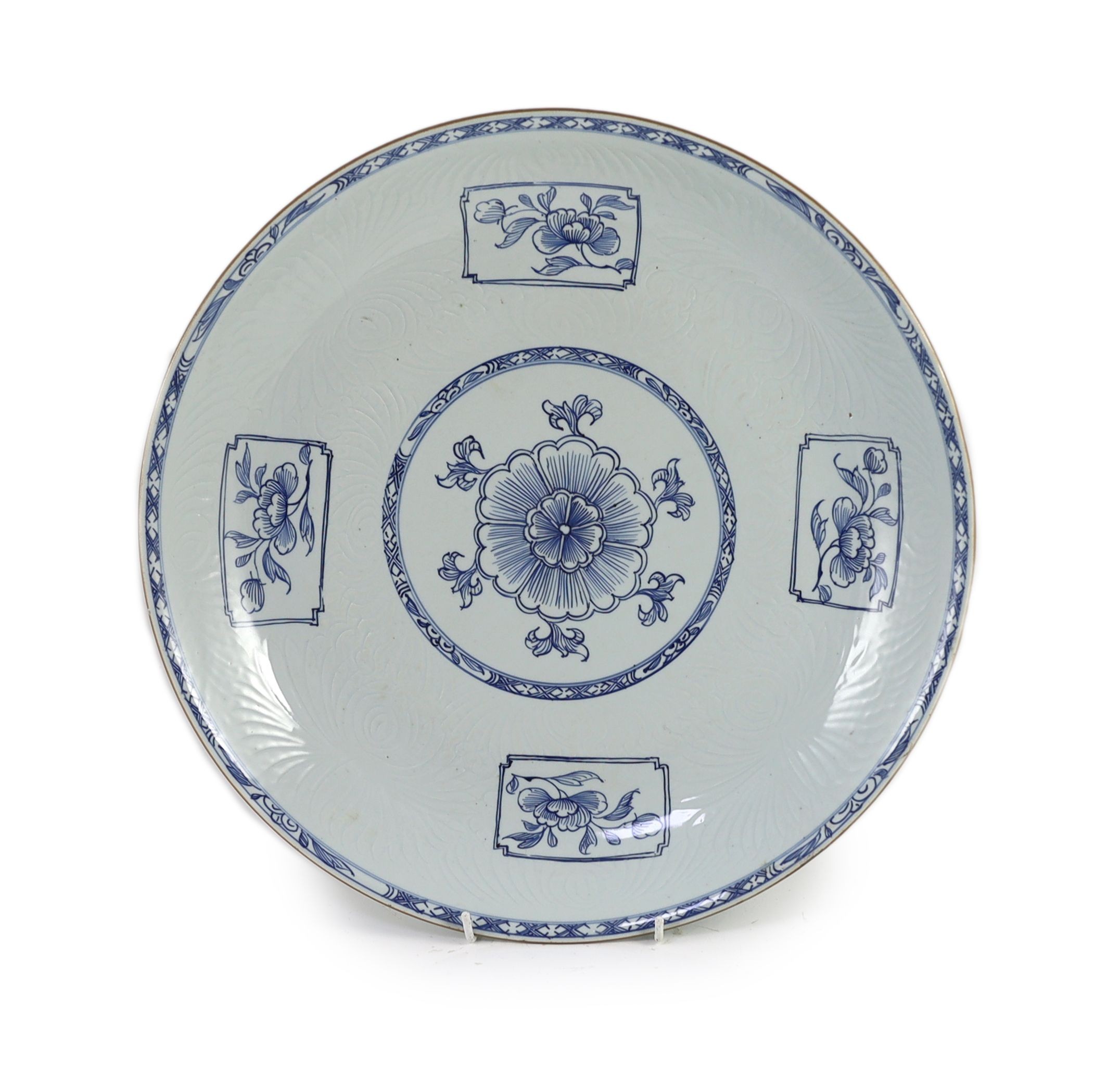 A Chinese carved blue and white dish, Yongzheng period, 39 cm diameter, restored chip